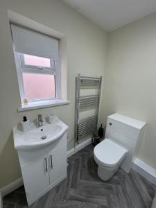 a bathroom with a toilet and a sink and a window at Birks Terrace - 2 Bedroom - Sleeps 4 in Cleator Moor +25 photos