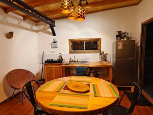 a kitchen with a wooden table and a refrigerator at Cabañas Refugio Costero in Pelluhue