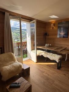 un soggiorno con tavolo, divano e finestra di Très bel appartement avec parking gratuit a Megève