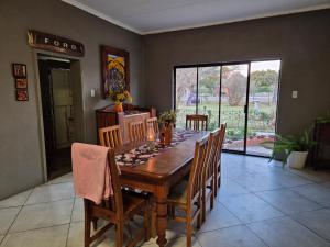 a dining room with a wooden table and chairs at Boemsies in Jacobsdal