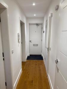 an empty hallway with white walls and wooden floors at Cosy apartment near Edinburgh city centre in Edinburgh