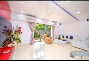 ロナバラにあるVilla Priyadarshiのリビングルーム(大きな窓、ソファ付)