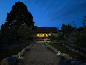 a house with a pathway in front of it at night at TarnApartman in Sirok