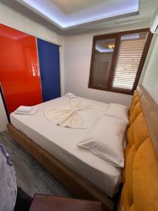 a bed in a small room with a window at Vila Behar - Penthouse Apartment with seaview in Sarandë