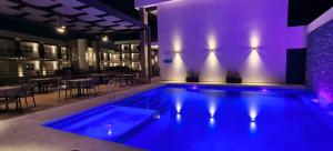 a swimming pool in a restaurant with purple lighting at Hotel Gran Avenida, Navojoa in Navojoa