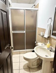a bathroom with a shower and a toilet and a sink at Apartamento céntrico y acogedor en Tegucigalpa in Tegucigalpa
