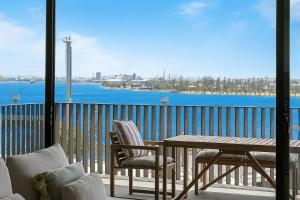 a balcony with a table and chairs and a view of the water at Salt & Stone - Harbour Views, Balcony & Parking x1 in Newcastle