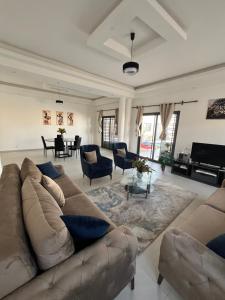 a large living room with a couch and chairs at Chez Léa Mariame in Malikounda