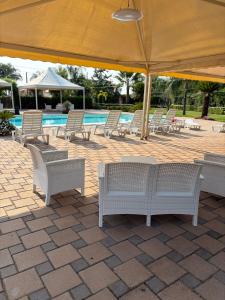 a group of chairs sitting under an umbrella next to a pool at B&B Alba Chiara in Taurianova