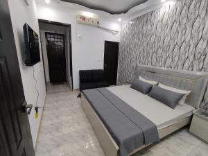 カラチにあるRest & Stayの部屋にベッドとテレビがある寝室
