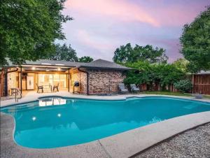 a swimming pool in front of a house at Family Haven Pool, Game Room, Near Cowboys Hq in Plano
