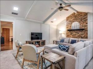 a living room with a couch and a tv at Family Haven Pool, Game Room, Near Cowboys Hq in Plano