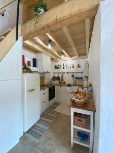 a kitchen with white appliances and a wooden ceiling at Casa de Alcaria in Alcaria