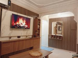 a living room with a fireplace and a tv on the wall at Airport view apartment Marrakech in Marrakesh