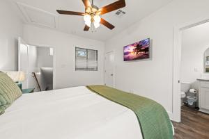 a bedroom with a white bed with a ceiling fan at The Cajun Shack King Bed Cajun Luxury in Lafayette