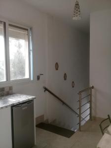 a white room with a staircase and a window at maison de charme au cœur du foret et plage de la grotte Bizerte in Banzart
