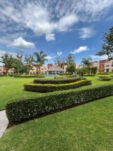 a garden with hedges and flowers in a park at Casa con Alberca en condominio in Yautepec de Zaragoza