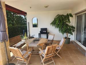 a patio with a wooden table and chairs at Appartement familial 118 m2 proche Bayonne in Hasparren +11 photos