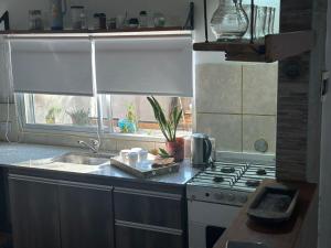 a kitchen with a sink and a stove and a window at HTA Hospedaje Turismo Aventura in San Fernando del Valle de Catamarca
