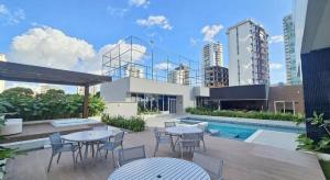 a patio with tables and chairs next to a pool at Apartamento Fantástico COP30 - 1o Aluguel - Novo! in Belém