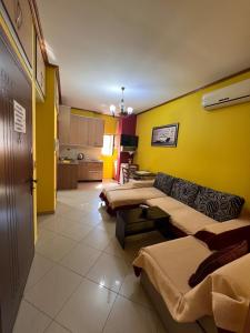 a room with three beds and a yellow wall at Villa Behar - wave in Sarandë