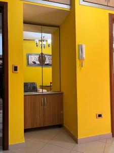 a yellow room with a mirror and a yellow wall at Villa Behar - wave in Sarandë
