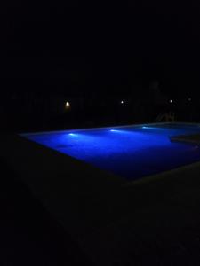 una piscina iluminada en la oscuridad en Bello atardecer Uribe, en Uribelarrea
