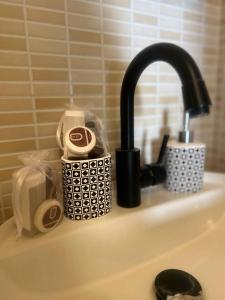 ナルドにあるCasinaBeaの黒い蛇口とトイレタリーを備えたバスルームのシンク