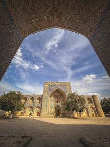 un gran edificio con un arco delante de él en SumayShakh Guest House, en Bukhara