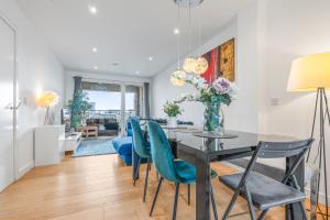 a dining room with a table and blue chairs at Luxury 3BR with 2bath Near Westfield Stratford in London