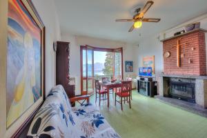 ein Wohnzimmer mit Tisch und Kamin in der Unterkunft La Finestra Sul Lago - Happy Rentals in Stresa