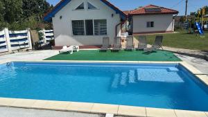 a swimming pool with chairs and a house at La Konac in Murighiol