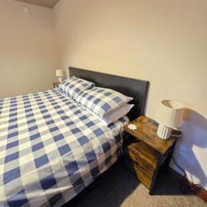 a bedroom with a bed and a table with a lamp at Swallow cottage in Howden