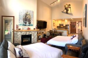 sala de estar con 2 camas y chimenea en XL Luxury Penthouse Ski-in Ski-out The Aspens, en Whistler