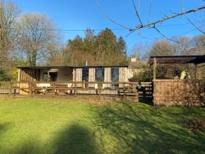 a house with a wooden fence and a yard at Hendre Glamping- Caravan Bryngwyn in Boncath