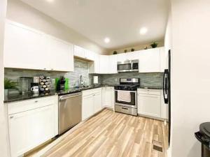 a kitchen with white cabinets and stainless steel appliances at 2 mins walk to Benz stadiumArcade game Sleeps 11 in Atlanta