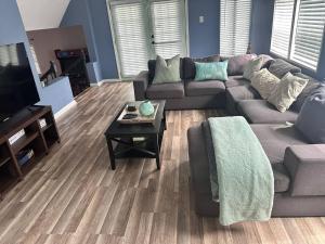 a living room with a couch and a coffee table at 2 Mins Walk To Benz Stadiumarcade Game Sleeps 11 in Atlanta