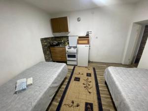 a small kitchen with two beds and a refrigerator at Markoski Basement in Kruševo