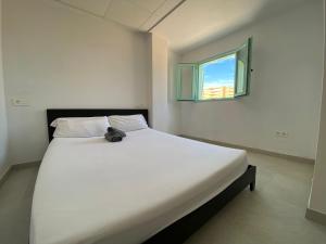 a bedroom with a large white bed with a window at Villatella in Burriana +19 photos