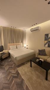 a bedroom with a bed and a couch and a table at شقة حي الوزارات in Riyadh