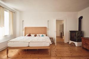 a bedroom with a large bed and a wood stove at Chalupa pri Donovaloch so saunou in Motyčky