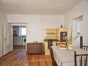 a dining room with a table and a kitchen at Chalupa pri Donovaloch so saunou in Motyčky