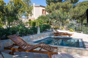 a patio with two chairs and a swimming pool at Feudo Del Biviere in Santa Ninfa