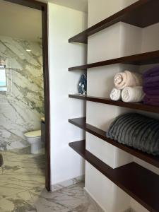 a bathroom with shelves with towels and a toilet at Beautiful sea view apartment in the Hotel Zone Cancun in Cancún +10 photos