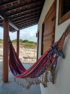 a hammock hanging from a building with the beach in the background at Loft 1 - Casa Aratu Guaiú Barra de Mamanguape in Rio Tinto +23 photos