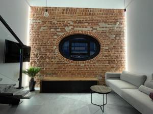 a living room with a brick wall and a couch at Nowe Młyny apartament 59 in Leszno