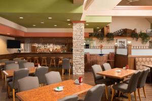 um restaurante com mesas e cadeiras e um bar em Travelodge Hotel by Wyndham Vancouver Airport em Richmond