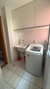 ein kleines Bad mit einem Waschbecken und einer Waschmaschine in der Unterkunft Apartamento Torres Dumont 3 quartos Hangar COP 30 e CÍRIO in Belém