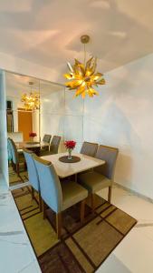 ein Esszimmer mit Tisch und Stühlen und einem Kronleuchter in der Unterkunft Apartamento Torres Dumont 3 quartos Hangar COP 30 e CÍRIO in Belém