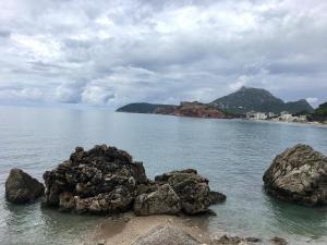 a large body of water with rocks in the water at Wonder home in Sutomore